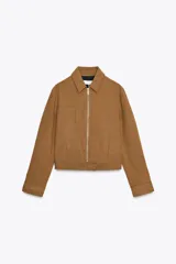 Cazadora color marrón de cuello solapa y manga larga acabada en puño con botón. Bolsillos de vivo en delantero, detalle de costuras marcadas, forro interior combinado a contraste y cierre frontal con cremallera y gancho metálico oculto.