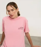 Remera de algodón BCI, color rosa claro con efecto desteñido, de corte oversized y cuello redondo. Presenta un pequeño bordado en el pecho con la frase "Core Queen" en color bordó.