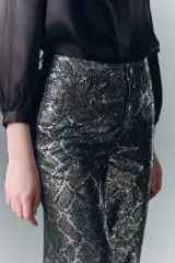 Pantalón oxford de cuero ovino con estampado reptil multicolor y detalles metalizados. Tiro alto, cinco bolsillos y pierna ancha desde la cadera.