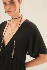 Vestido corto negro con escote en V y efecto foil. Presenta mangas amplias tipo mariposa y un corte holgado con frunce bajo el busto.