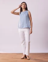 Blusa sin mangas color beige, de crepe. Cuello a la base con frunce, apertura ojal y botón.