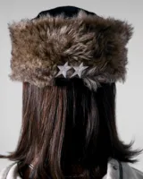 Gorra de pana negra con orejeras forradas en piel sintética y visera plana. Presenta un bordado frontal con el nombre de la marca Twojeys, estrellas y texto decorativo en color blanco.