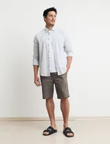 Camisa sport de algodón con cuello button-down y manga larga. Diseño a rayas verticales en tonos gris y blanco. Cierre frontal con botones de madera.