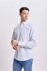 Camisa celeste a rayas verticales blancas, de corte clásico, con cuello abotonado, manga larga y bolsillo en el pecho.