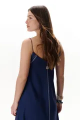 Vestido largo color crudo con breteles finos y costuras a la vista en color azul.