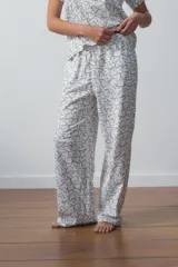Conjunto de pijama blanco con estampado de corazones negros, compuesto por una remera de manga corta con bolsillo en el pecho y un pantalón largo de corte recto.