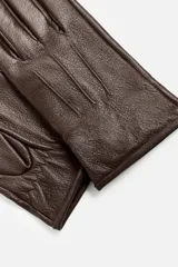 Guantes de cuero marrón con forro interior de punto y ajuste elástico en la muñeca.