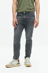 Jean slim azul oscuro, tiro medio, con pasacintos y confeccionado en 98% algodón y 2% spandex.