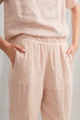 Pantalón de lino color salmón, de corte holgado, con cintura elástica y bolsillos laterales.