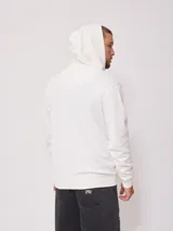Canguro blanco con cierre frontal, capucha con cordones ajustables y logo de la marca bordado en el pecho.