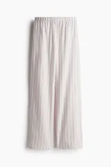 Pantalón de pijama de algodón suave con rayas verticales, corte relajado, tiro bajo, cintura elástica, cierre decorativo con botones y bolsillos laterales.