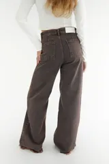 Pantalón de jean color marrón con corte recto y ruedo desflecado.