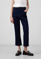 Pantalón tobillero de denim azul oscuro, con pespuntes a contraste, cierre con botón metálico, trabillas, cinco bolsillos y corte flare.