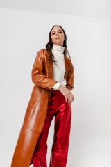 Tapado largo de cuero negro, de corte recto, sin botones ni bolsillos y cuello a la base.