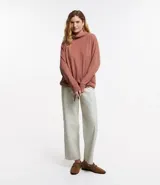 Polera hecha en tela canalé con tacto peluche, color ladrillo, con cuello alto, mangas largas y lazo en el bajo.