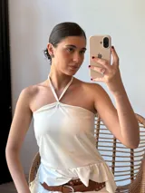 Top blanco con cuello halter y espalda descubierta.