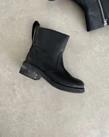 Botín marrón de cuero vacuno, con caña media, cierre lateral y suela de goma.