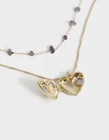 Collar corto dorado de doble cadena, una con piedras amatistas y otra con dije de corazón relicario.