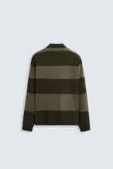 Polo relaxed fit de punto tejido en hilatura de algodón, a rayas horizontales en tonos azul y negro. Cuello solapa con cierre frontal de botonadura, manga larga y acabados en rib.