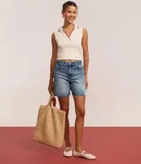 Bermuda de jean celeste con lavado dirty, tiro alto, corte amplio y terminación deshilachada.