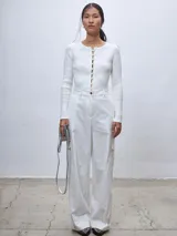 Pantalón de vestir blanco de corte ancho, con bolsillos laterales y traseros.