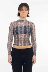 Remera de lycra traslúcida con cuello alto y estampado de piel de serpiente en tonos marrones y negros.