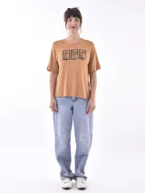Remera color ocre con estampado de tres leopardos enmarcados y texto inferior.