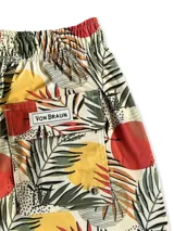 Short de baño blanco con estampado de hojas de palmera en tonos verde, rojo y amarillo.