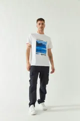 Remera blanca de algodón de manga corta con cuello redondo y estampado rectangular con imagen de paisaje y texto "SAVE THE MOMENT" y logo de la marca Mistral en el frente.