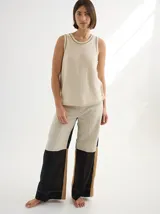 Chaleco tejido color crema con cuello redondo y rayas verticales marrones.