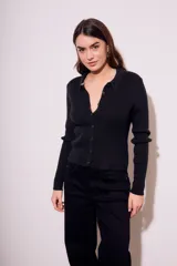 Cardigan negro de punto con cuello polo, manga larga y cierre frontal con botones.
