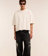 Pantalón masculino super baggy confeccionado en jeans sostenible con cintura con trabilla, cierre tradicional, bolsillos y estampa de grafiti.