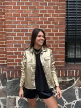 Chaqueta plateada metalizada con cuello camisero, cierre frontal con botones, bolsillos de parche en el pecho y corte recto.