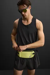 Riñonera deportiva color amarillo flúor, con cierre de cremallera termosellada, bolsillo interno con cremallera y doble mosquetón. Cuenta con banda elástica frontal y asa ajustable con hebilla de liberación rápida.