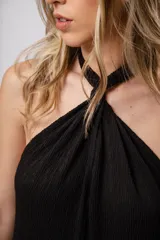 Mono largo negro de punto con escote halter y corte palazzo. Incluye un collar largo con dijes de estrellas plateadas.