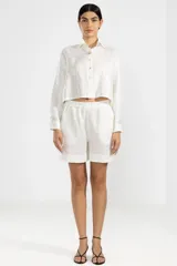 Camisa corta blanca de lino italiano con hilo metalizado, cuello clásico y botón de flor en el cuello.