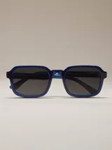 Lentes de sol negros con marco cuadrado y lentes azules degradados.