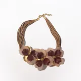 Collar corto con múltiples tiras de cuero sintético color beige y apliques de flores grandes en tonos rosa, borgoña y dorado.