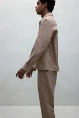 Pantalón de vestir color beige con textura de lino, corte recto, bolsillos laterales y traseros con botón. Cierre con cremallera y botón oculto.