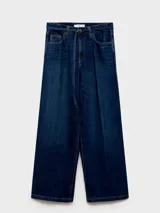 Pantalón de jean azul oscuro, de corte wide leg, tiro medio, con cinco bolsillos y cierre frontal con cremallera y botón.