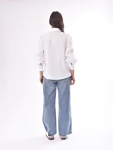 Camisa verde oliva con rayas verticales en relieve, corte clásico, cuello camisero, cierre frontal con botones blancos, mangas largas abullonadas con puños elastizados.