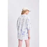 Camisa oversize de manga corta con estampado de palmeras y limones en tonos azules sobre fondo blanco. Confeccionada en lino.