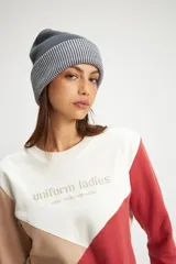 Gorro de lana tejido con efecto bicolor, diseño con vuelta y oreja decorativa.