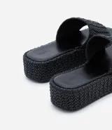Sandalia flatform negra con superficie trenzada, tira ancha y puntera redonda.