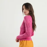 Sweater rosa con cuello redondo y mangas largas.