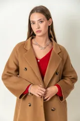 Tapado largo color camel, confeccionado en lana. Tiene doble botonadura, cuello con solapa y lazo para ajustar en la cintura.