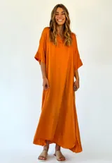 Vestido largo color naranja, con corte holgado y cuello en V.