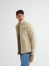 Camisaco de sherpa color beige con botones y bolsillos con solapa en el pecho.
