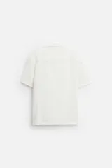 Camisa celeste de corte recto, manga corta y cuello solapa.