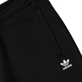 Shorts deportivos Adidas Originals Trefoil Essentials, color negro, confeccionados en mezcla de algodón y poliéster reciclado. Presentan cintura elástica y el logo Trefoil bordado en blanco en la pierna izquierda.